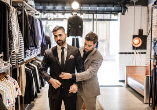 Young man at tailor shop, trying on a new suit.